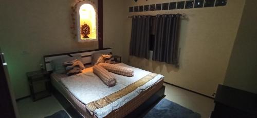 a bedroom with a bed with pillows on it at Touch the Wind in Chaiyaphum