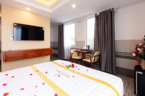 a hotel room with a bed and a flat screen tv at Rockmila Hotel in Phu Quoc