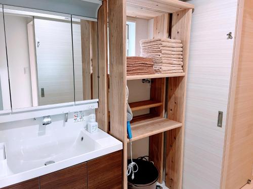 ein Bad mit einem Waschbecken und einem Spiegel in der Unterkunft 海まで3分BBQテラス付き貸別荘 バケーションレンタルハウス Nalu resort Japan in Ichinomiya