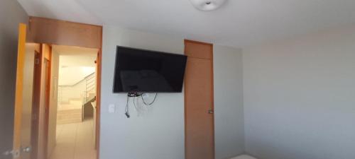 a flat screen tv hanging on a wall in a room at Apartamento duplex, con terraza y vista de Chiclayo in Chiclayo