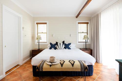 a bedroom with a large white bed with blue pillows at Jackson Ranch by Bannisters in Bawley Point
