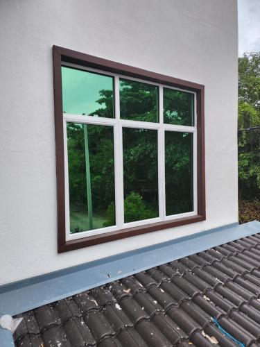 een raam aan de zijkant van een huis bij Inap Homestay in Kuala Terengganu