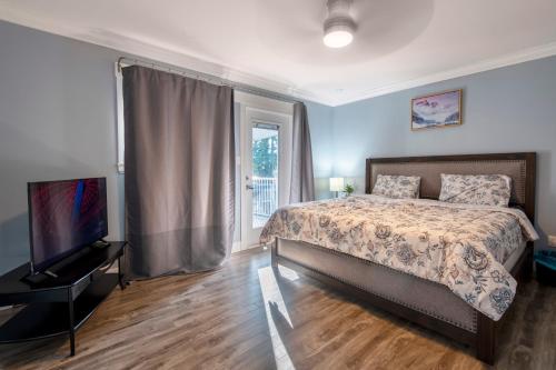 a bedroom with a bed and a flat screen tv at CHEERFuL 2 LEVEL HOUSE 4 BED 3 BATH PARKiNG in Delta