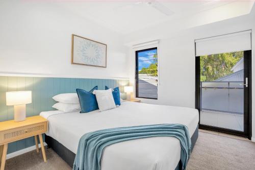 a bedroom with a large bed and a window at Elysium Apartments in Palm Cove