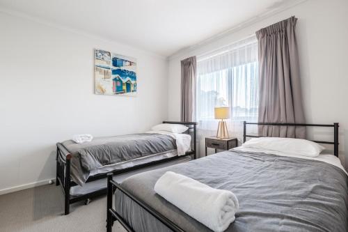 a bedroom with two beds and a window at Ocean Vista in Lakes Entrance