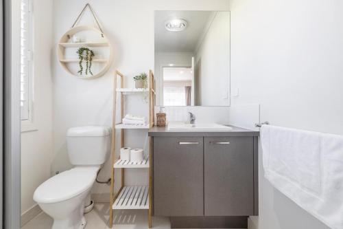 a bathroom with a toilet and a sink and a mirror at Ocean Vista in Lakes Entrance