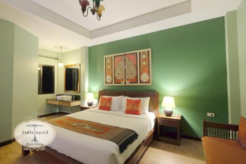 a bedroom with a bed and a green wall at Wualai Sabaidee in Chiang Mai