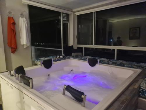 y baño con bañera grande con iluminación púrpura. en La Vista EcoHouse, en Macanal