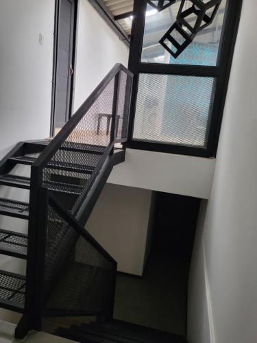a staircase in a building with black railing and windows at Casa Azul - Apartamentos Amoblados - in Manizales