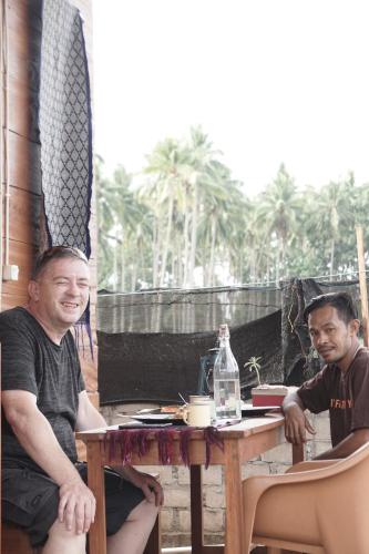 a couple of men sitting at a table at Sinuan homestay- Jabu 02 in Pandanga