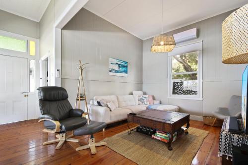 a living room with a couch and a table at Howitt House - Central Metung Village Retreat in Metung