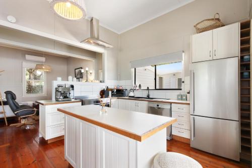 a kitchen with white cabinets and a large island at Howitt House - Central Metung Village Retreat in Metung