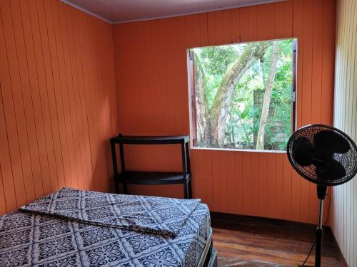 1 dormitorio con cama y ventana en CASA VERO CAHUITA, A 100 M. DEL PARQUE NACIONAL en Cahuita