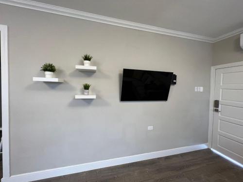 a living room with a tv on a white wall at SHAK Condos- Luxury, Functionality and Comfort in Saint Helena