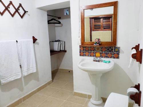 een badkamer met een wastafel en een spiegel bij Cabañas Pájaro Azul in Akil