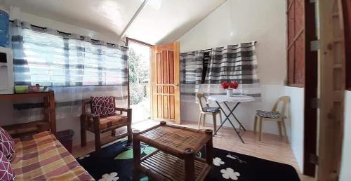 uma sala de estar com uma mesa e uma mesa e cadeiras em A&C Aquino's Guesthouse & Motorbike Rental - Moalboal em Moalboal
