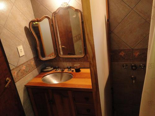 een badkamer met een wastafel en een spiegel bij Abedules in Dina Huapi