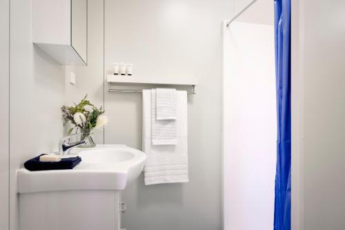 ein weißes Bad mit einem Waschbecken und einer Dusche in der Unterkunft Red Sands Accommodation Newman in Newman