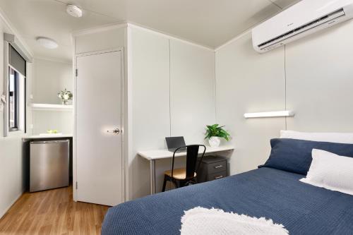 纽曼Red Sands Accommodation Newman的一间卧室配有蓝色的床和一张书桌