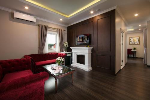 a living room with a red couch and a fireplace at Flora Centre Hotel & Spa in Hanoi