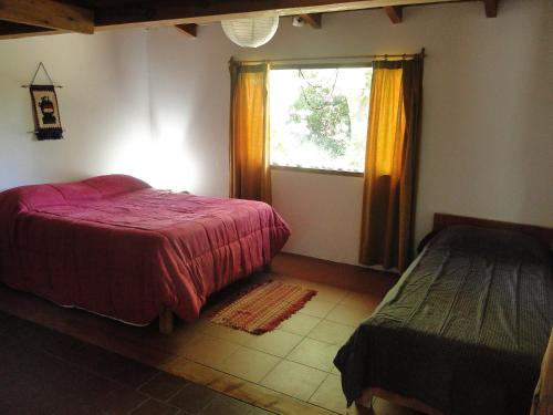 a bedroom with a red bed and a window at Abedules in Dina Huapi