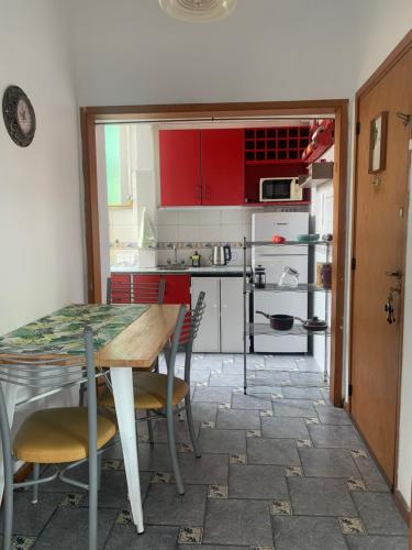 une cuisine avec des placards rouges, une table et des chaises dans l'établissement Departamento Barrio Abasto, à Buenos Aires
