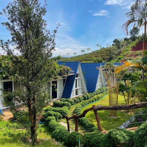 a house with a garden with bushes and a tree at Homestay Tulip Garden Bảo Lộc in Bao Loc