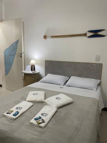 a bed with three pillows on top of it at Casa em condomínio fechado Paraty - KG Home in Paraty