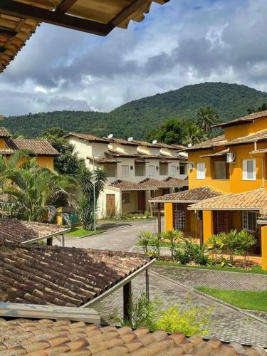 a group of buildings with mountains in the background at Casa em condomínio fechado Paraty - KG Home in Paraty