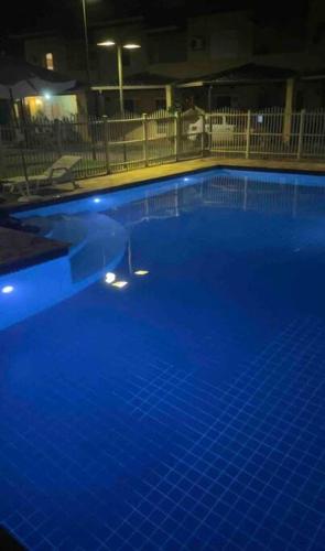 a large blue swimming pool at night at Casa em condomínio fechado Paraty - KG Home in Paraty
