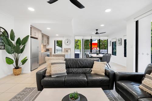 a living room with a black leather couch at Elysium Apartments in Palm Cove