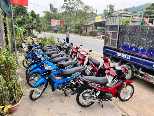a row of motorcycles parked next to a truck at Rosie Villa Ha Giang - Motorbikerental & Tour in Ha Giang