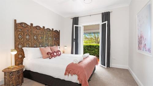 a bedroom with a large bed and a window at Cowley House in Dapto