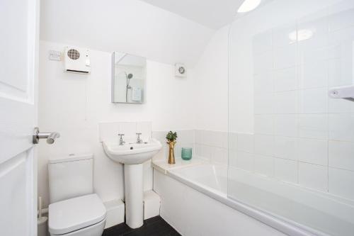 a white bathroom with a sink and a toilet at Elmsleigh Lofts by Sorted Stay in Southend-on-Sea