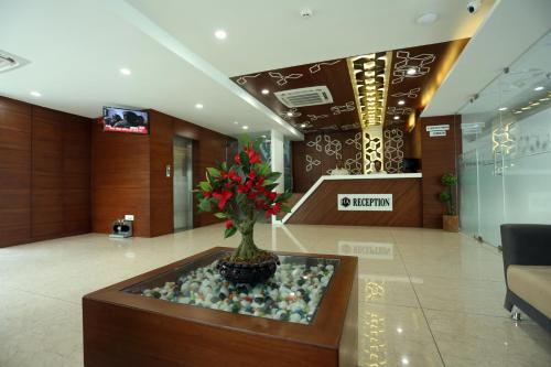 a lobby with a vase with a plant in it at Hotel Avista in Vadodara