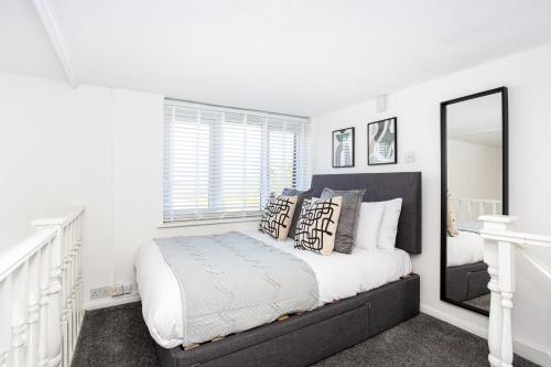 a bedroom with a large bed and a mirror at Elmsleigh Lofts by Sorted Stay in Southend-on-Sea