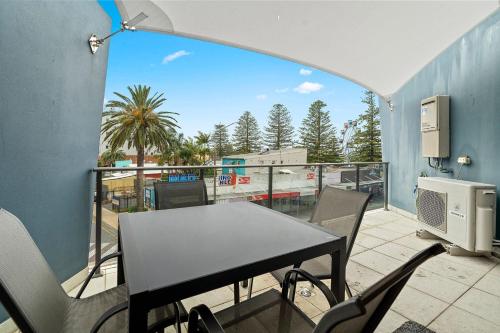 Il dispose d'une terrasse avec une table et des chaises. dans l'établissement Coast on Coral Luxury Apartment Unit 15, à Entrance