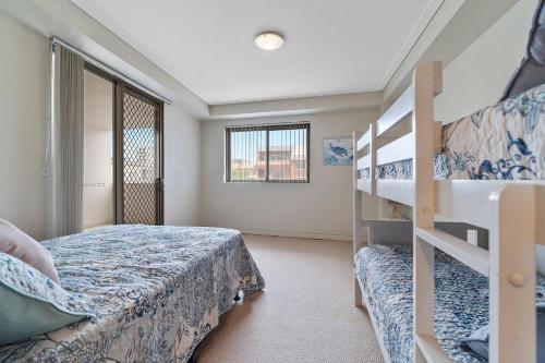 1 dormitorio con 2 literas y escalera en Coast on Coral Luxury Apartment Unit 15, en The Entrance