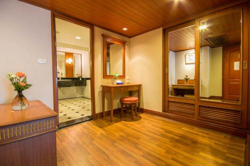 a room with a hallway with a vanity and a mirror at Golden Tulip Sovereign Hotel Bangkok in Bangkok