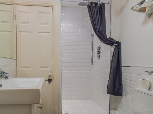 a white bathroom with a shower and a sink at Spencers in Ryde