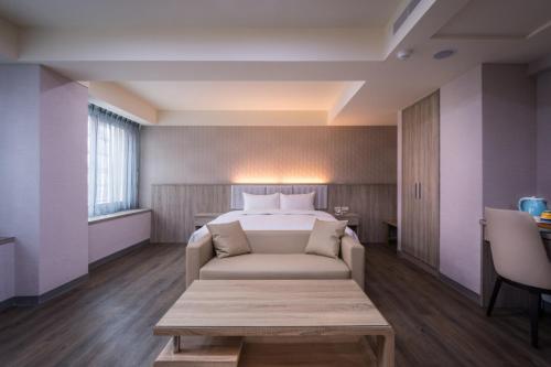 a hotel room with a bed and a couch at Mei Hotel in Taichung