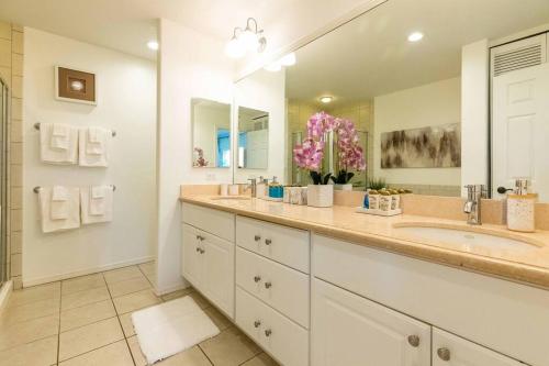 a bathroom with two sinks and a large mirror at Hilton Pool Pass Included - Stylish Central Villa Mins to Beach Pool & Spa in Waikoloa
