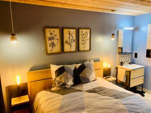 a bedroom with a bed with three paintings on the wall at Apartment in Morzine - Ski In - Sleeps 6 in Morzine