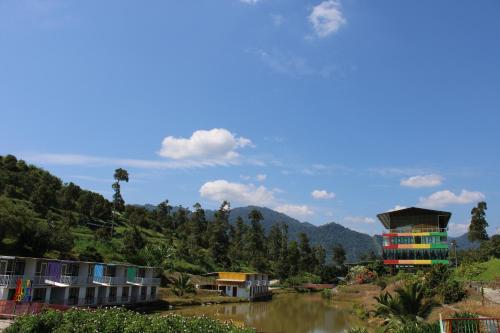 a group of houses on a hill next to a river at Happy Valley Eco Farm in Kerling