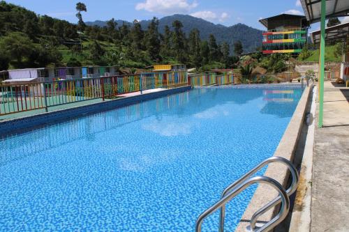 a swimming pool at a resort with mountains in the background at Happy Valley Eco Farm in Kerling