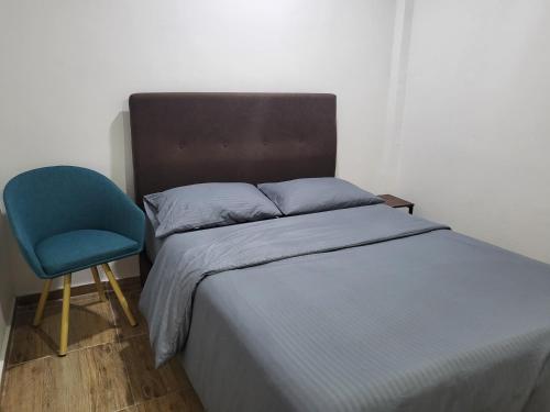 a bedroom with a bed and a blue chair at Casa Azul - Apartamentos Amoblados - in Manizales