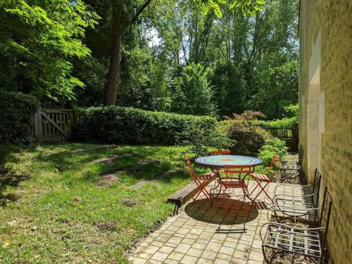 a table and chairs sitting on a brick patio at Gîte spacieux avec jardin privatif, animaux, accès PMR, pêche, randonnées et équipements bébé inclus - FR-1-653-191 in Guizengeard