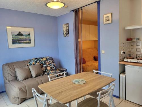 un salon avec une table et un canapé dans l'établissement Studio avec Terrasse, Parking Privé et Accès Direct à la Plage - FR-1-465-86, à Merville-Franceville-Plage