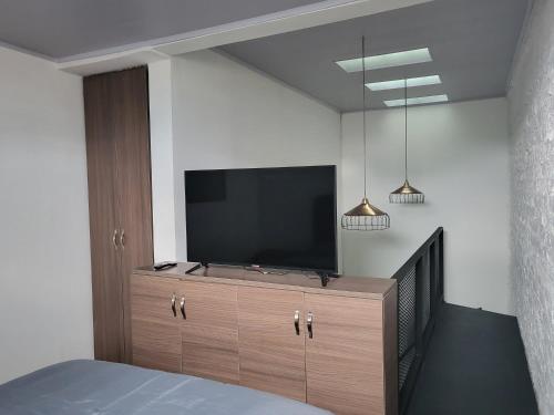 馬尼薩萊斯的住宿－Casa Azul，一间卧室,在橱柜上配有一台平面电视