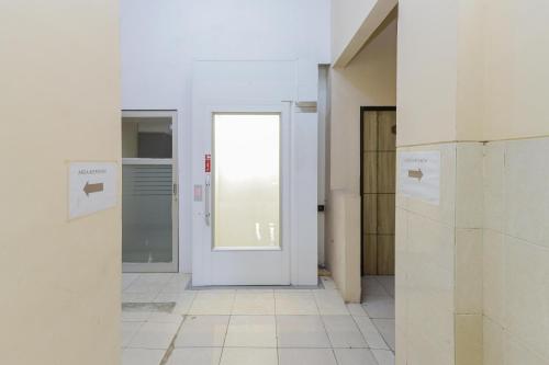 a hallway with a white door in a room at RedDoorz Syariah @ Klojen Malang in Malang